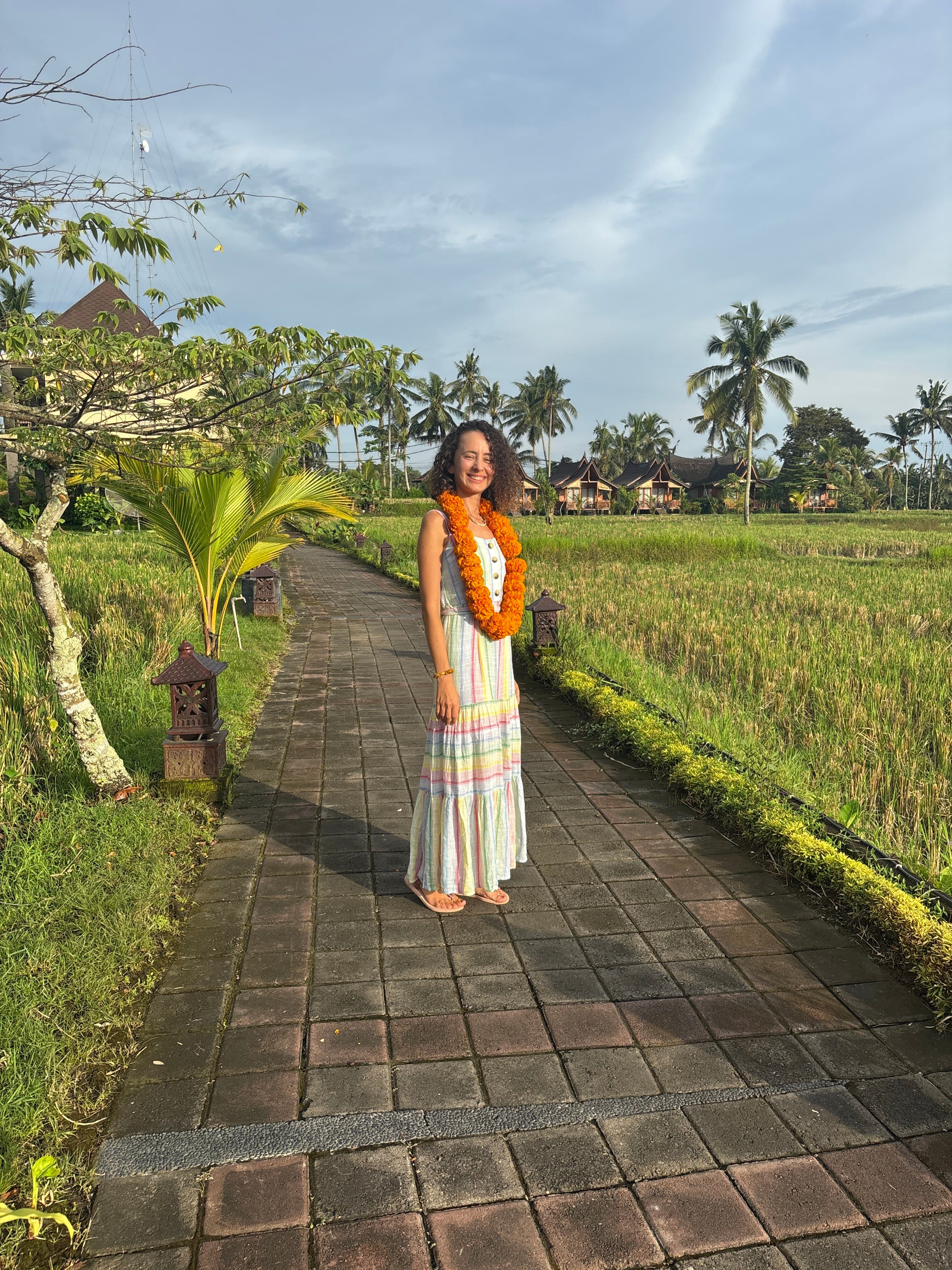 Melis in Bali, wearing a marigold garland among the rice fields