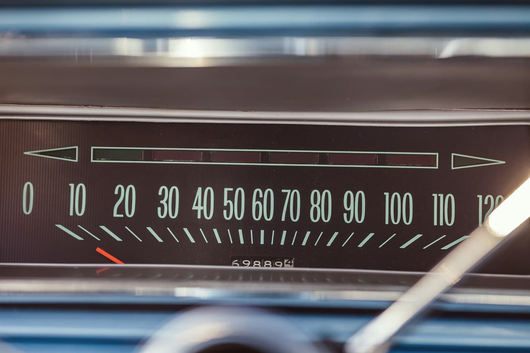 An old car speedometer, the needle near zero
